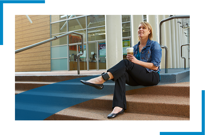 Women stitting in the step holding a cup- electronic monitoring device attached in the leg